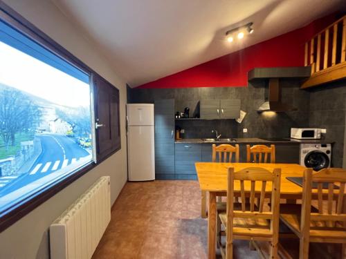cocina y comedor con mesa y sillas en La Vall Apartaments Dúplex, en Sant Llorenç de Morunys