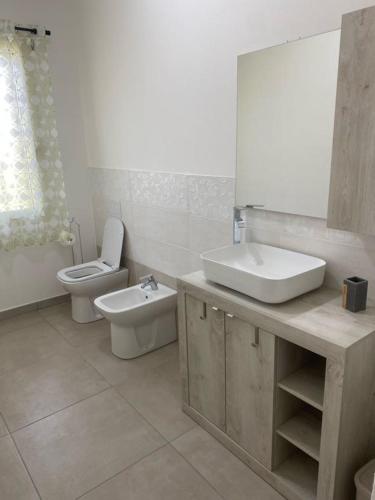 a bathroom with a sink and a toilet and a mirror at La Campanula-exclusive pool in Santa Maria a Monte