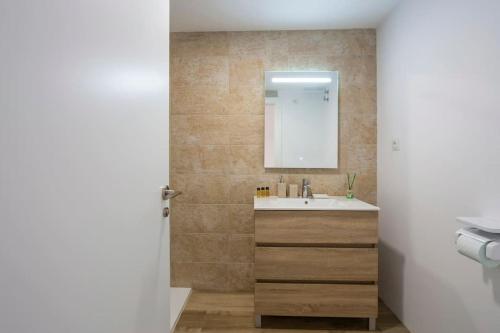 La salle de bains est pourvue d'un lavabo et d'un miroir. dans l'établissement Golden Glow Bungalow with AC and pool, à Caserío Cañada
