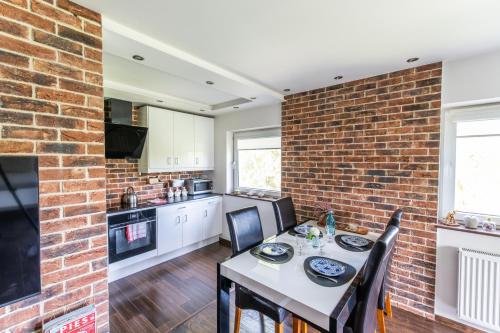 a kitchen and dining room with a brick wall at LARGE LUXURY APARTMENT WIELICZKA in Wieliczka