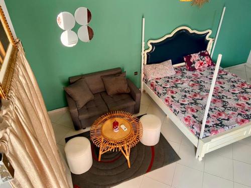 ein Schlafzimmer mit einem Bett, einem Tisch und einem Stuhl in der Unterkunft Plage Ewell in Cotonou