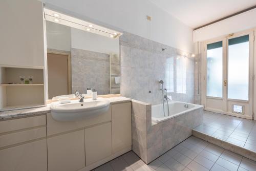 baño blanco con bañera, lavamanos y bañera tubermott en VERRAZZANO BRIDGE APARTMENT (2 bathrooms & Free WiFi) en Florencia