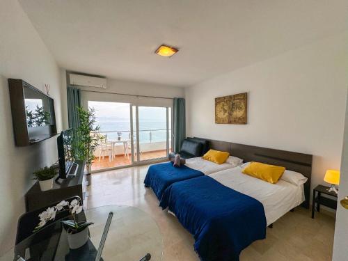 a bedroom with two beds and a glass table at Spectacular Sea Views Torremolinos in Torremolinos