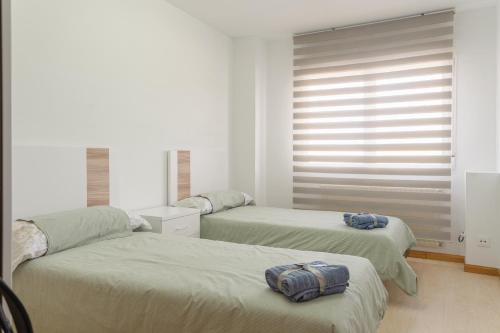 - une chambre avec 2 lits et une fenêtre dans l'établissement CASA CHARROS, à Saragosse
