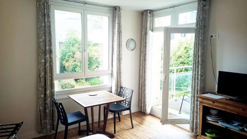 a dining room with a table and chairs and a window at Voiles et Terrasses Le Treport in Le Tréport