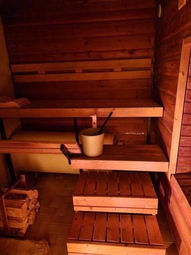 an inside of a sauna with a bucket and a cup at Villa Kataja in Siuntio