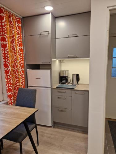 a small kitchen with a table and a refrigerator at Villa Kataja in Siuntio