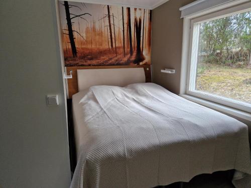 - une petite chambre avec un lit et une fenêtre dans l'établissement Villa Kataja, à Sjundeå