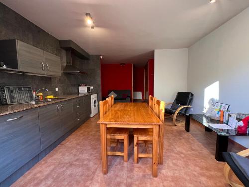 a kitchen with a wooden table and a dining room at La Vall Apartaments Loft in Sant Llorenç de Morunys