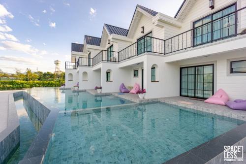 a swimming pool in front of a house at The Autumn Creek Chiangrai in Chiang Rai