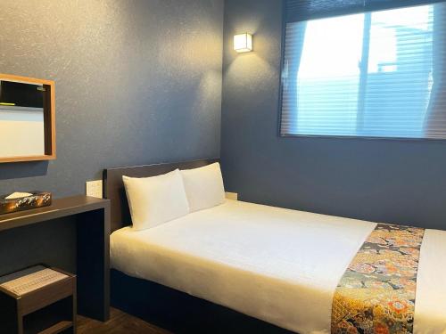 a small bedroom with a bed and a window at Guest House Wagokoro in Tokyo