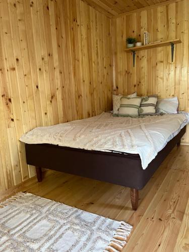 Cama en habitación con pared de madera en Metsamajake Värskas, en Värska