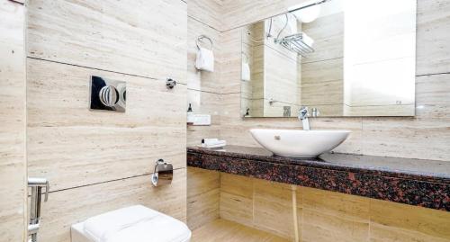 een badkamer met een wastafel en een toilet bij Hotel De Huespedes near international airport in New Delhi