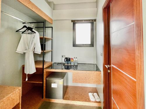 a small bathroom with a sink and a door at ProudChan Boutique Resort in Chanthaburi