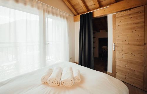 3 toallas en una cama con ventana en Chalet familial de 6 chambres dominant Saint-Gervais classé 4 étoiles, en Saint-Gervais-les-Bains