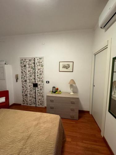 a bedroom with a bed and a dresser and a window at Residenza Reno 10 in Lamezia Terme
