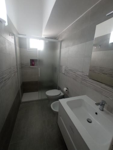 a white bathroom with a toilet and a sink at Casa Scottodiuccio in Procida