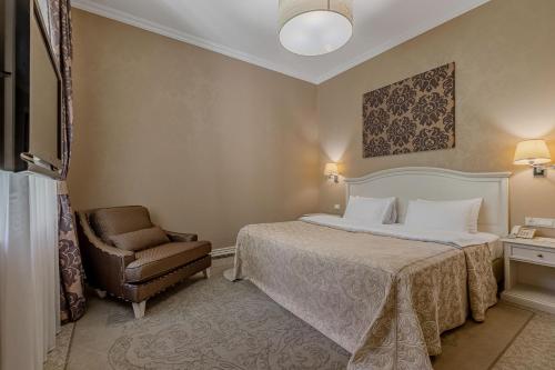 a hotel room with a bed and a chair at Palace Del Mar in Odesa