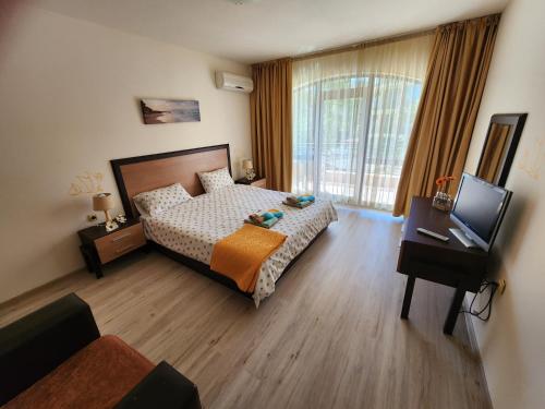 ein Schlafzimmer mit Bett, Schreibtisch und Fernseher in der Unterkunft Villa Bonita Apartment in Sonnenstrand