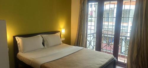 a bedroom with a bed and a large window at Edassery Cokkers tower in Kodaikānāl