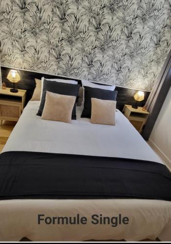 une chambre avec un grand lit blanc avec une grande tête de lit dans l'établissement Le Boisclary, à Boissy-Saint-Léger