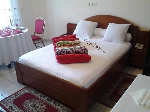 a bedroom with a bed with four pillows on it at Bau rivage hotel in Akwa