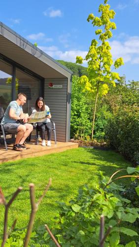 two people sitting at a table in a yard at Sauerland Tinyworld in Diemelsee