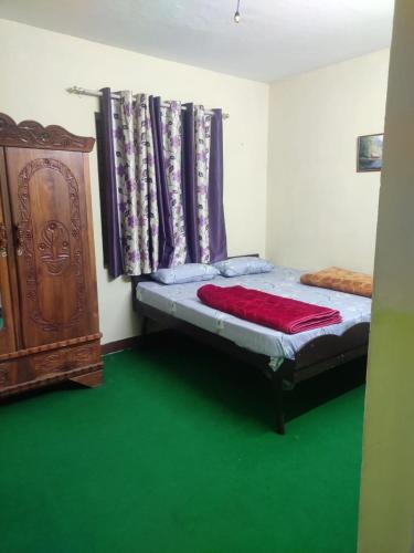 a bedroom with a bed and a dresser and green floors at Edassery Cokkers tower in Kodaikānāl