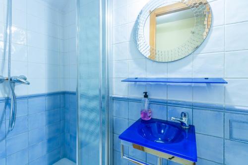 y baño con lavabo azul y ducha. en Apartamento Mirador de la Ribera, en Córdoba