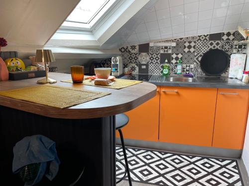 a kitchen with orange cabinets and a counter top at Studio VITRÉ CENTRE in Vitré