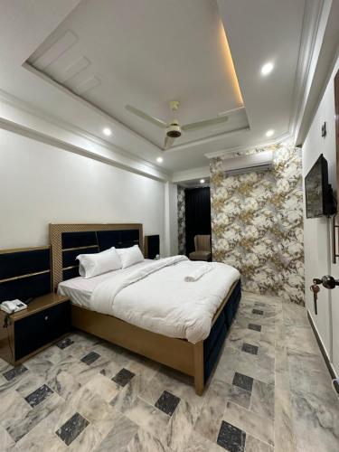 1 dormitorio con 1 cama grande en una habitación en Hotel Flower of Capital en Islamabad