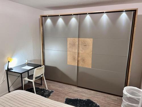 a bedroom with a sliding door with a desk and a bed at Moderne ruhige Wohnung Bochum angebunden in Bochum