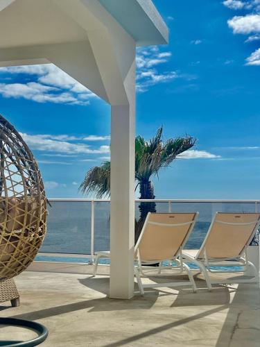 two chairs on a balcony overlooking the ocean at Sunset house in Paul do Mar