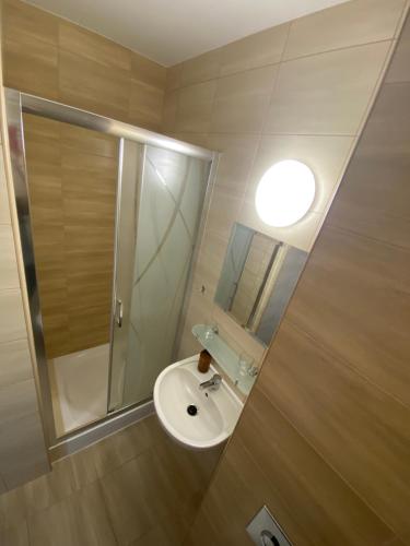 a small bathroom with a sink and a shower at Hotelik Zełwągi in Mikołajki