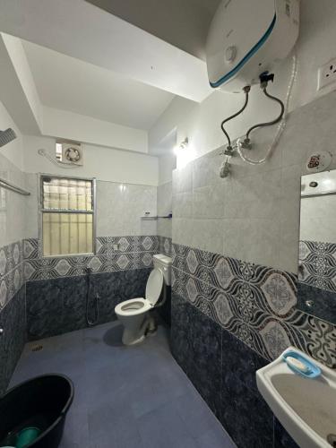 y baño con aseo y lavamanos. en Pearl villa homestay, en Jorhāt