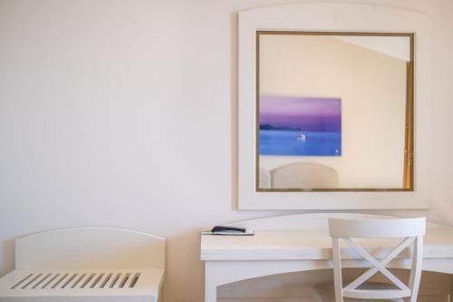 a white desk with a mirror and a chair at Hotel Punta Negra in Alghero