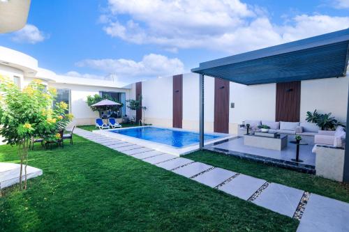 a backyard with a swimming pool and a house at Arjan Park Resorts in Riyadh