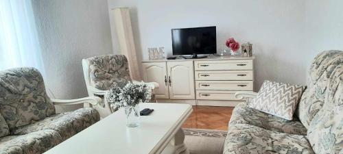 a living room with two chairs and a tv at Dream in Otočac