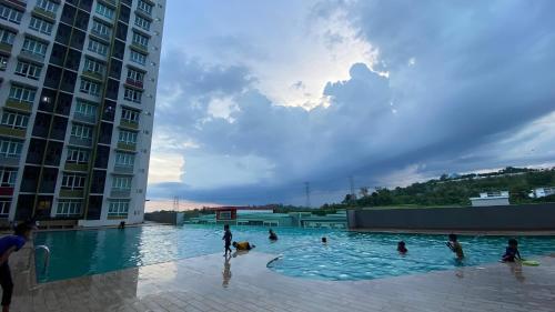 a group of people in a swimming pool next to buildings at Mahkota Valley Pool View Studio Suite Indera Mahkota Kuantan near UIA in Kuantan
