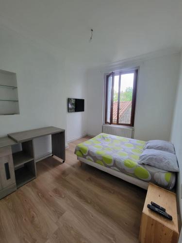 Schlafzimmer mit einem Bett, einem Schreibtisch und einem Fenster in der Unterkunft Chambres spacieuses hyper centre in Saint-Étienne
