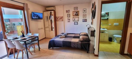 1 dormitorio con cama, mesa y baño en Monolocale + Ampio Terrazzo en Grosseto