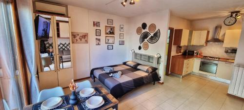 1 dormitorio con cama, mesa y cocina en Monolocale + Ampio Terrazzo en Grosseto