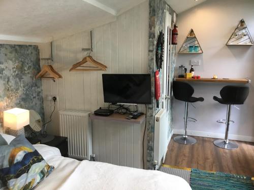 a bedroom with a bed and a tv on a wall at The Granary Country Retreat in Lampeter
