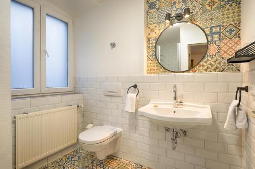La salle de bains est pourvue d'un lavabo, de toilettes et d'un miroir. dans l'établissement Brauereigasthof Bären, à Titisee-Neustadt