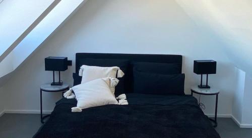 a bedroom with a bed with pillows and two lamps at Suite One Löwengrube in Munich