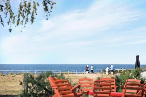 a group of orange chairs sitting on the beach at Feriehus med havudsigt in Hasle