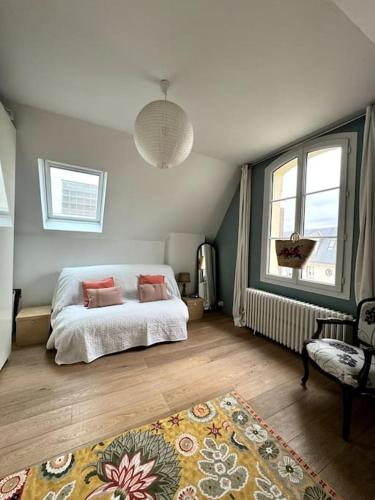 une chambre avec un lit et une grande fenêtre dans l'établissement Charming family home to rent for holidays & only 10 mins to Paris, à Colombes