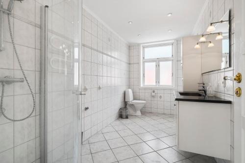 uma casa de banho branca com um chuveiro e um WC. em Feriehus med havudsigt em Hasle