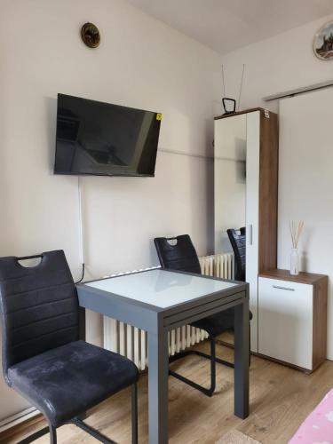 Zimmer mit einem Tisch, einem Stuhl und einem TV in der Unterkunft Rebro apartman in Zagreb