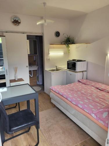 Schlafzimmer mit einem Bett, einem Tisch und einem Schreibtisch in der Unterkunft Rebro apartman in Zagreb